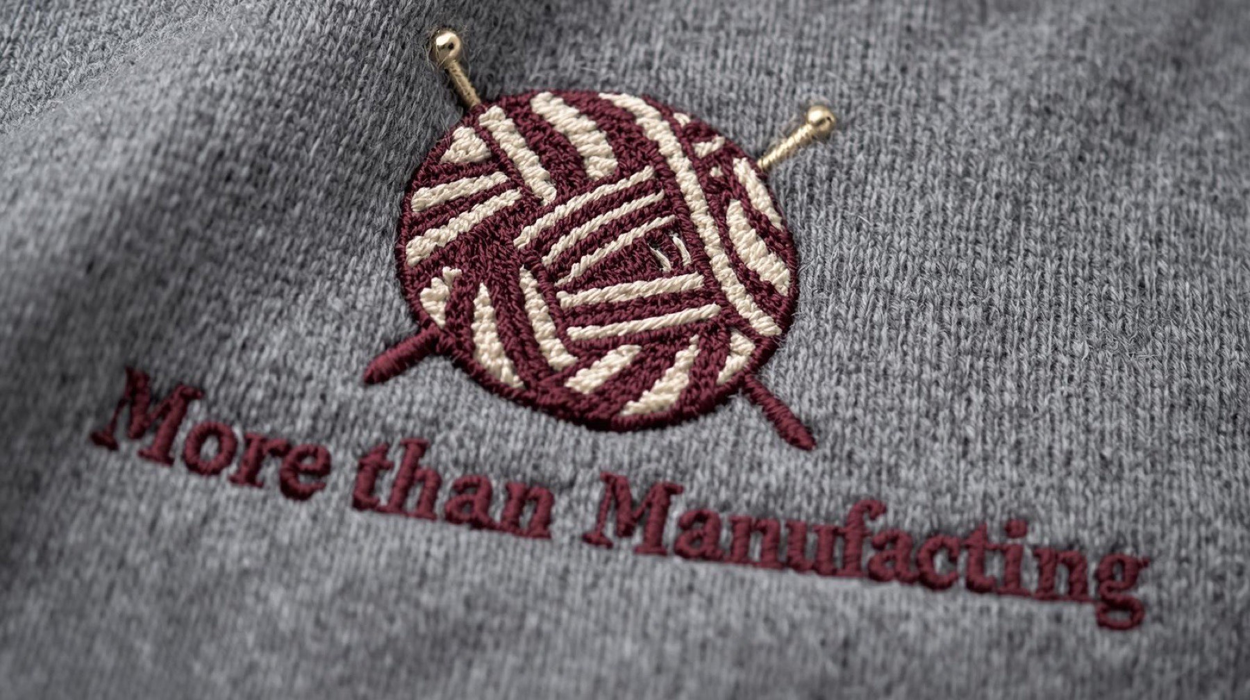 Dense embroidery of a yarn-ball mark on grey knit